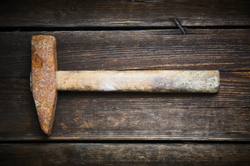 Close up of old used hammer on a rustic wooden background. Selective focus