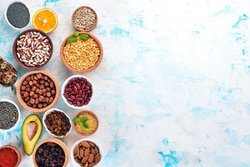 Healthy food. Superfoods Nuts, berries, fruits, and legumes. On a white stone background. Top view. Free copy space.
