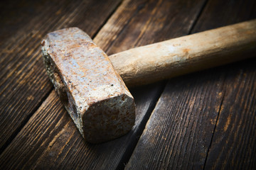 Close up of old used hammer on a rustic wooden background. Selective focus