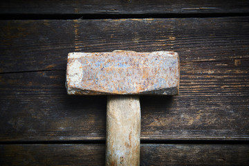 Close up of old used hammer on a rustic wooden background. Selective focus