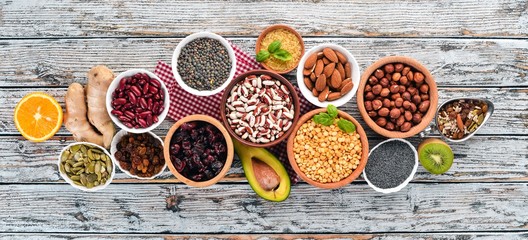 Superfoods Healthy food. Nuts, berries, fruits, and legumes. On a white wooden background. Top...