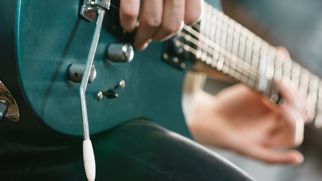 Close up of man playing on electric guitar