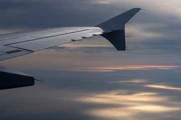 Fototapeta na wymiar Blick aus dem Flugzeug auf eine Tragfläche mit beleuchtetem Mittelmeer