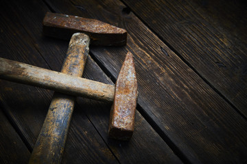 Close up of two old used hammer on a rustic wooden background. Selective focus