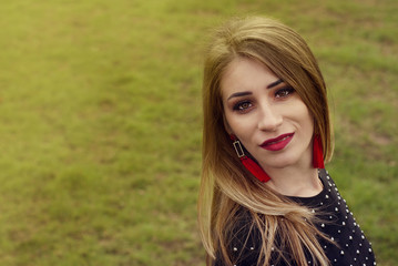 Naklejka premium Portrait of a beautiful fashion young women smiling, with red lips, in park, Copy space.