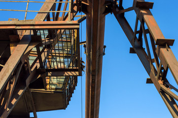 gantry crane, telpher, old, ancient, past, broken, abandoned, rusty, closed production, work; orange; metal; environment; vintage; old; ancient; past; broken; abandoned; rusty; closed production