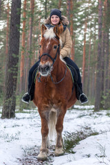 Fototapeta premium Cheerful nice girl with a horse. Country Equestrian Club. Winter trip out of town