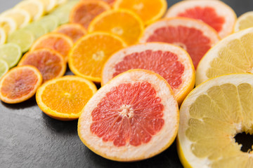 food and healthy eating concept - close up of grapefruit, orange, pomelo, lemon and lime slices