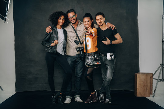 Studio shot of photographer standing with his crew