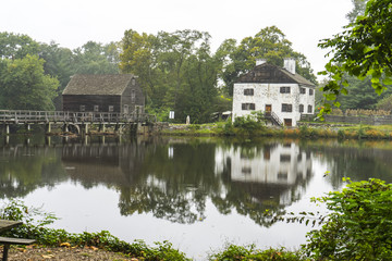 Fototapeta na wymiar Reflection of a wood mill and a farm 