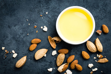 Obraz na płótnie Canvas Almond oil in bowl and almond nuts. Almonds