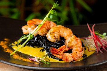 Thai fine dining/ Fresh cilantro marinated “Black Tiger” shrimps and mango sauce on black noodles