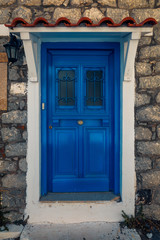 Scenic shot of a picturesque door entrance into a stone house  painted in the greek colours on Samothrace Island in the city of Samothraki