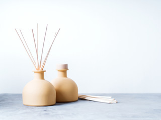 aroma reed diffuser home fragrance with rattan sticks on a light background with palm leaves and...