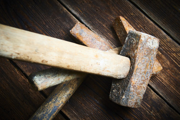 Close up of tree old used hammer on a rustic wooden background. Selective focus