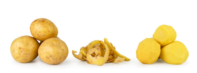 Bunch of potatoes, potato peels and peeled potatoes close up on a white background.