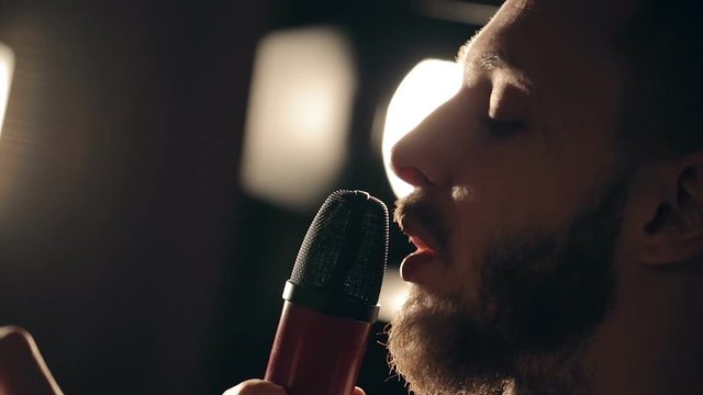 Close up shot of singer in the studio. Close up shot of microphone and man's face