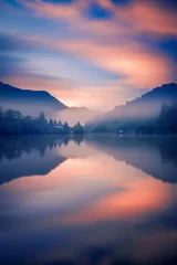 Fotobehang Mistige ochtend op een meer in de bergen met enkele huizen aan de kust, geschoten met lange belichtingstijd © ionutpetrea