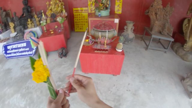 Lighting candle in Phuket Thailand Temple, POV