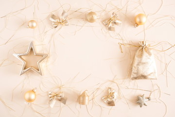 Naklejka na ściany i meble Christmas composition. Christmas golden decorations, pine cone, star, gift, balls on pastel beige background. Flat lay, top view, copy space 