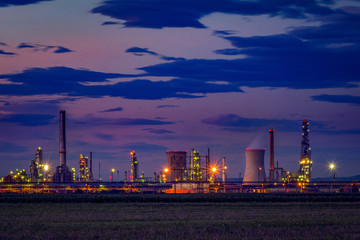 Petrol oil refinery located near a cultivated field at dusk
