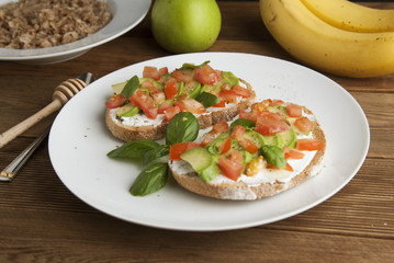 Homemade Healthy Toast sandwich with Avocado, cheese cream and tomatoe on wooden board. Breakfast healthy food.