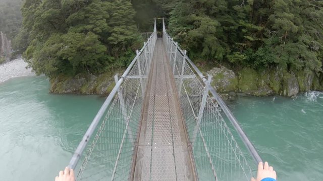 Walking over river bridge in New Zealand, POV