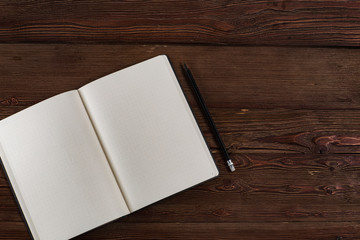 Fototapeta premium an empty outdoor diary with a pencil on a wooden background