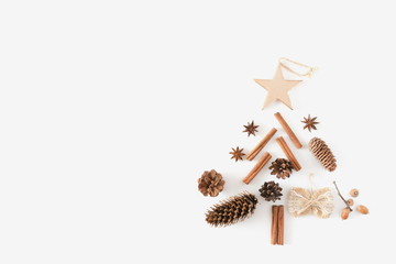 Christmas tree made of cinnamon sticks, anise star, cones, nuts, acorn. Christmas, winter, new year concept. Flat lay, top view, copy space 