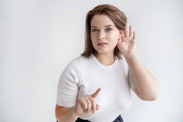 Young woman asking to keep silent when she is listening. Portrait of pretty young woman...