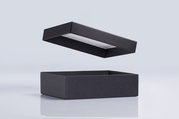 Black square gift box with openning lid on a light background