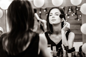 portrait of beautiful young woman doing makeup. Image in black and white color style