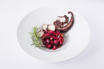 Salad from beet and octopus. Vinegret is a traditional Russian salad made from beets and vegetables. The background is white. Copy space. Horizontal shot.