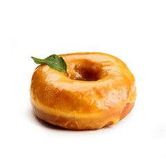 Donut with honey glaze and a leaf of mind, isolated on white background. View from side.