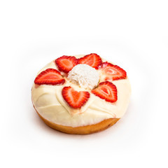 Donut with white cream and strawberry slices, isolated on white background. Viewing forty-five degrees.