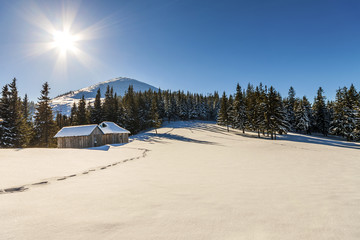 Beautiful winter landscape in the mountains with snow path in steppe and small little house. Happy New Year celebration concept.