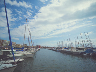 Fototapeta na wymiar Luxury yacht marina. Port in Mediterranean sea. Sailing boats with a deflated sails near the sea pier.