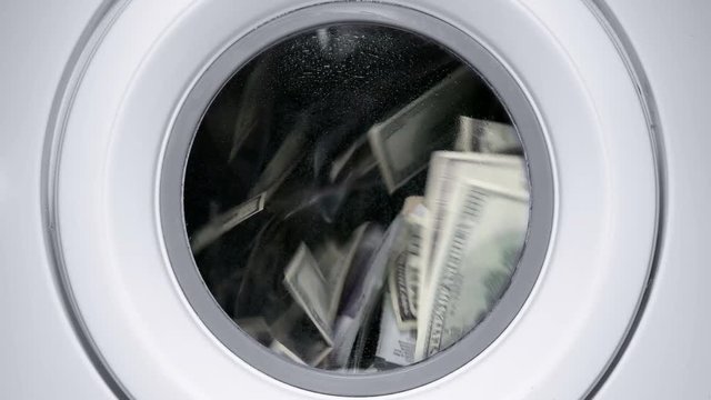 in a drum of a washing machine, money and dollars are spinning and laundered, close-up