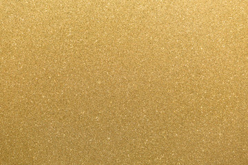 Golden glitter orange yellow surface with blinking white irregular spots, copy space background.