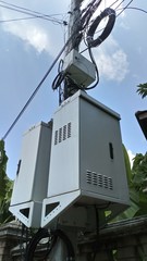 Big transformer ,power cord , light pole and sky background.