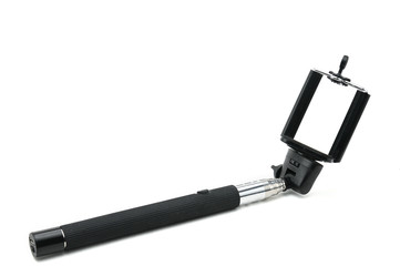 Selfie stick and smartphone on an isolated white background