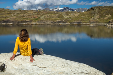 femme contemplant , méditant au bord d' un lac en montagne dans les alpes , france