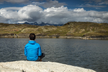 homme contemplant , méditant au bord d' un lac en montagne dans les alpes , france