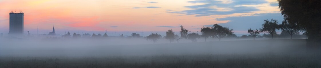 Village and orchard overwhelmed by fog