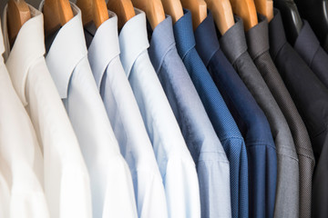 Office Business shirts hanging in a closet ordered by colour