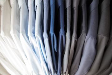 Office Business shirts hanging in a closet ordered by colour