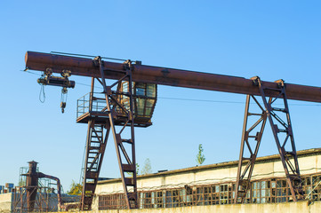 .gantry crane, telpher, old, ancient, past, broken, abandoned, rusty, closed production, work; orange; metal; environment; vintage; old; ancient; past; broken; abandoned; rusty; closed production