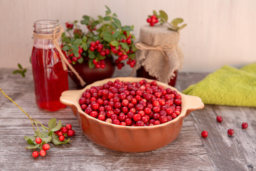Fresh lingonberries, lingonberry drink, jam, cinnamon and pears on the table. Healthy food. Lingonberry, horizontal, rustic style.