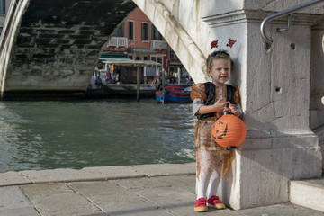 Obraz premium Little girl dressed up for Halloween, posing at the bridge of Scalzi Venice Italy 