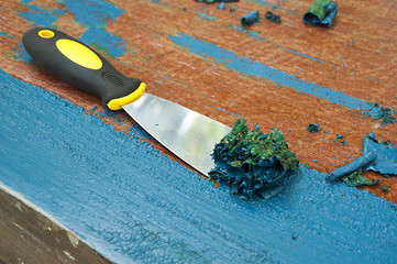 renovation furniture - removing blue painting with spatula